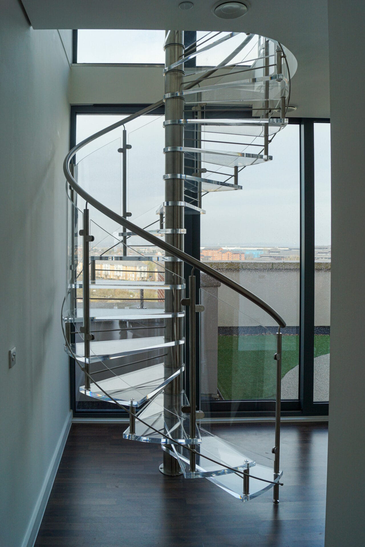 View of Penthouse Spiral Staircase with glass treads from Paradigm Stairs